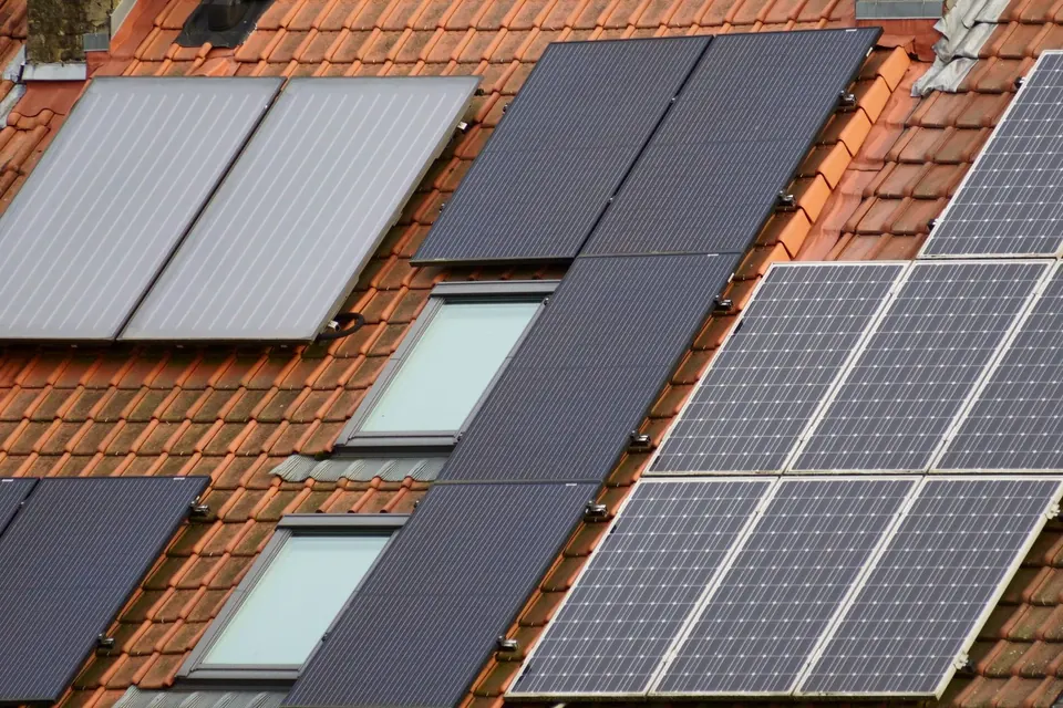 Capteurs solaires thermiques plans et panneaux photovoltaïques sur un toit de tuiles