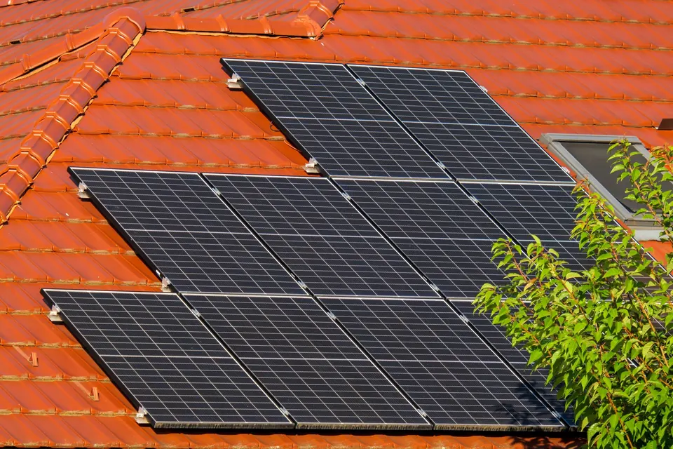 Panneaux photovoltaïques sur un toit de tuiles rouges